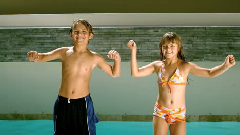 siblings dancing together in front of the swimming pool