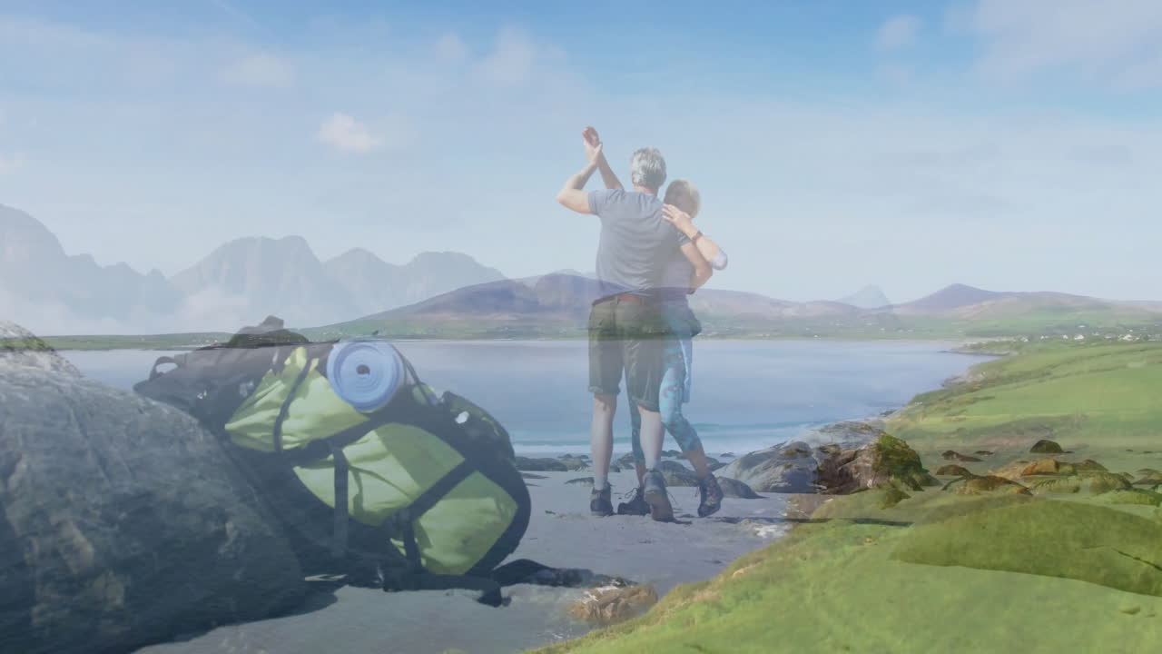 hiker couple dancing on rocky beach, with animated health chart and heart icon overlays