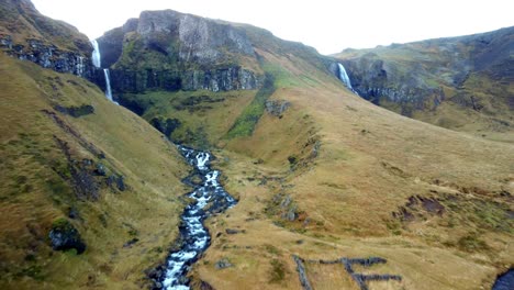 Drone-flying-over-a-beautiful-blue-mountain-river-flowing-through-the-mountains