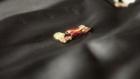 Close-up-of-two-small-insignia-Spanish-medals-on-the-groom's-black-military-jacket