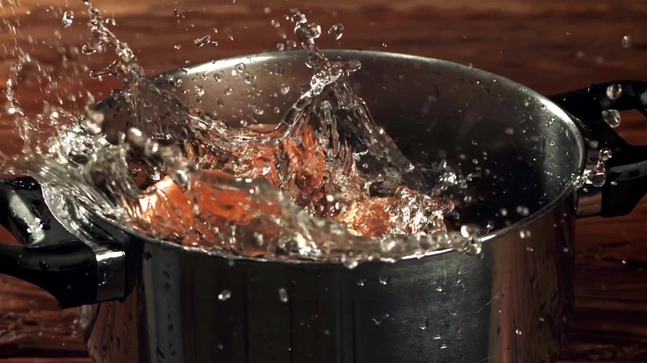 Cipolle che schizzano nell'acqua in una pentola al rallentatore