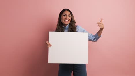 woman holding a blank panel and pointing around
