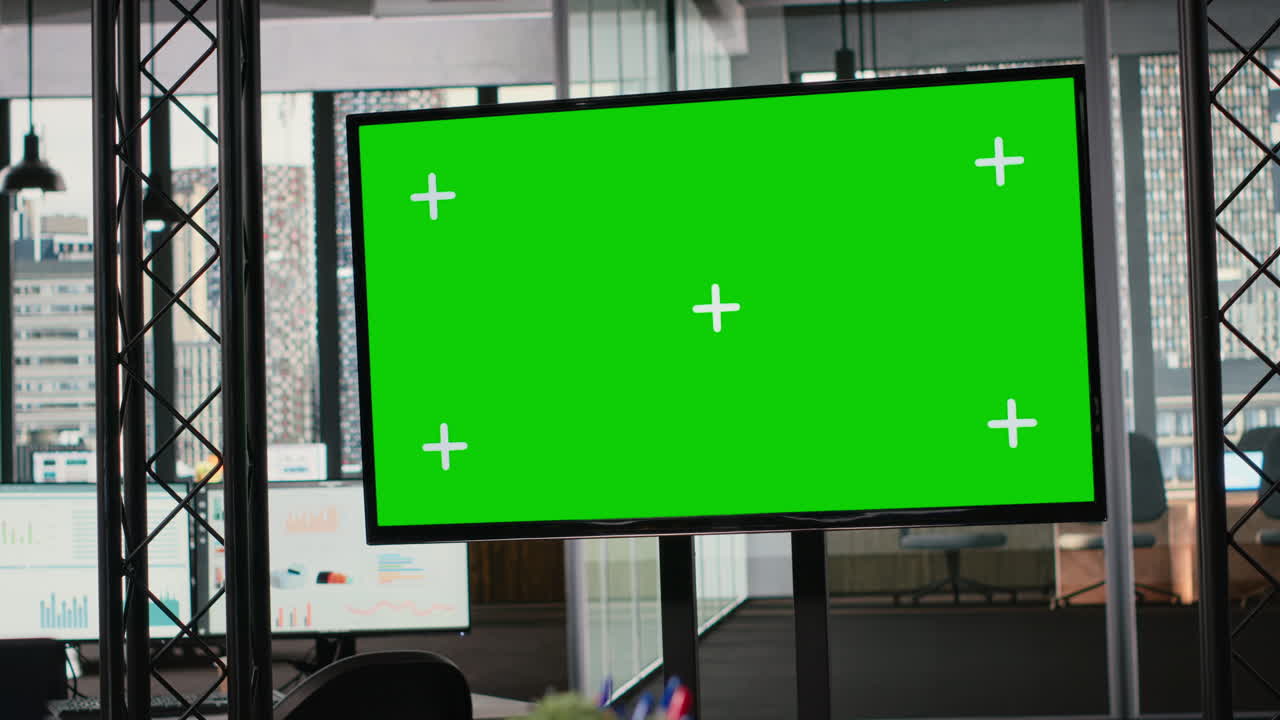 Empty workstation in modern office offers green screen display
