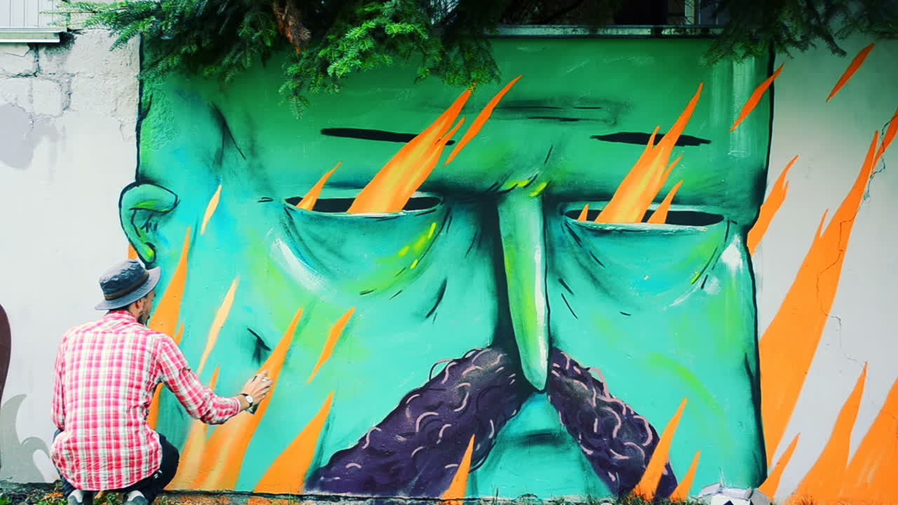 L'artista disegna graffiti su una recinzione. Graffiti su una recinzione.