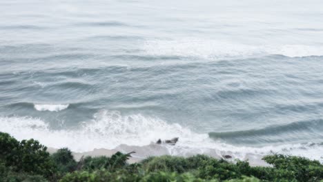 Vista-Aérea-De-Las-Olas-Del-Mar-Rompiendo-Contra-Un-Acantilado