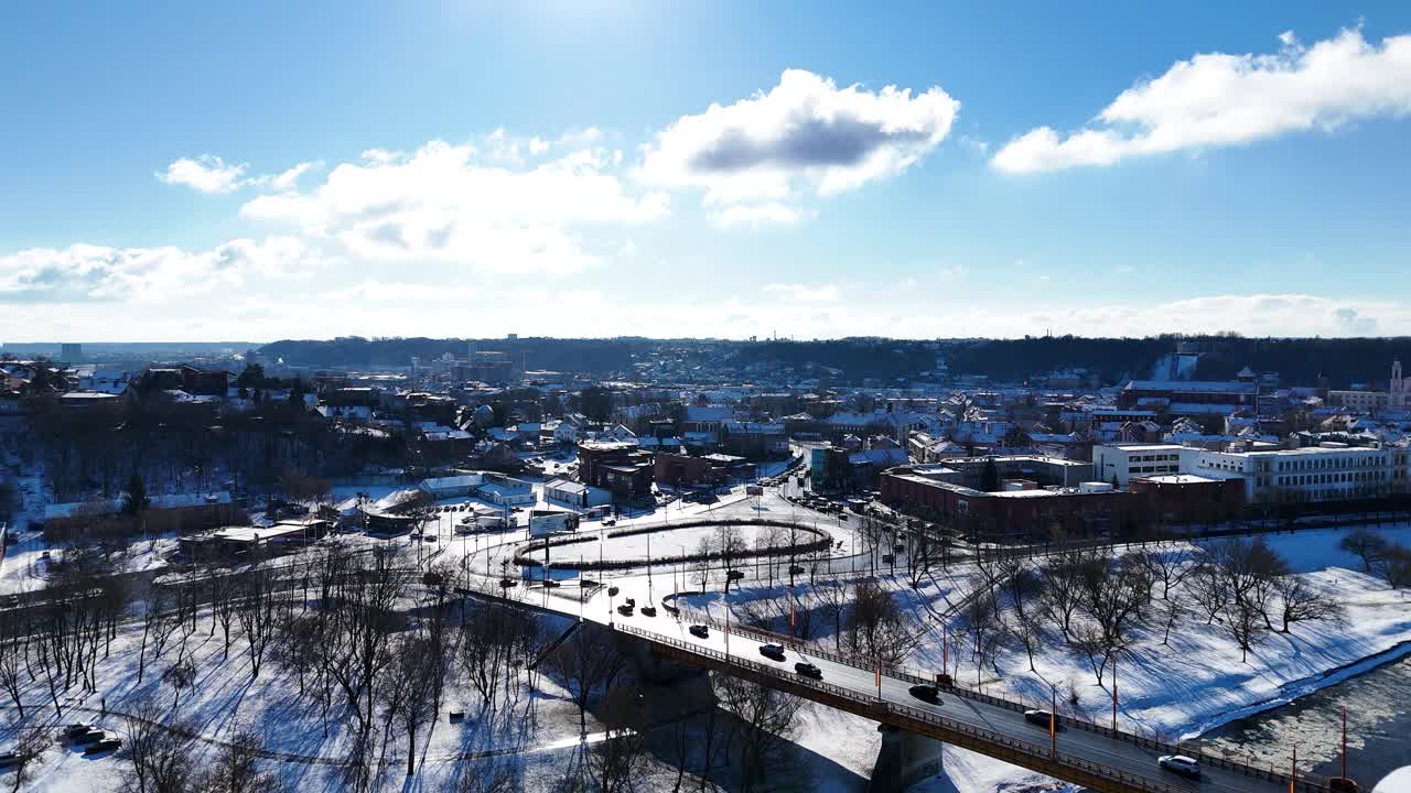 Bridge over icy river and Kaunas city old town, aerial view