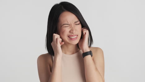 Asian-woman-covering-her-ears-on-camera.