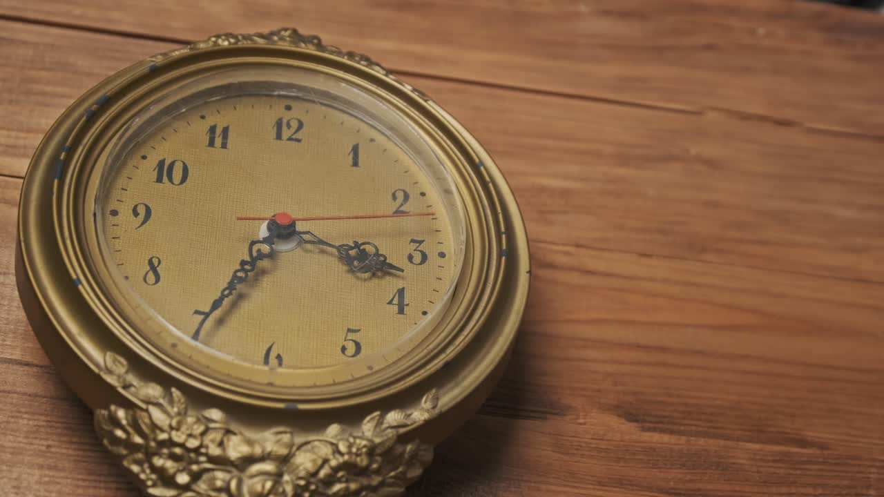 Gammel retro veggklokke med bevegelig sekundviser på trefarget bakgrunn