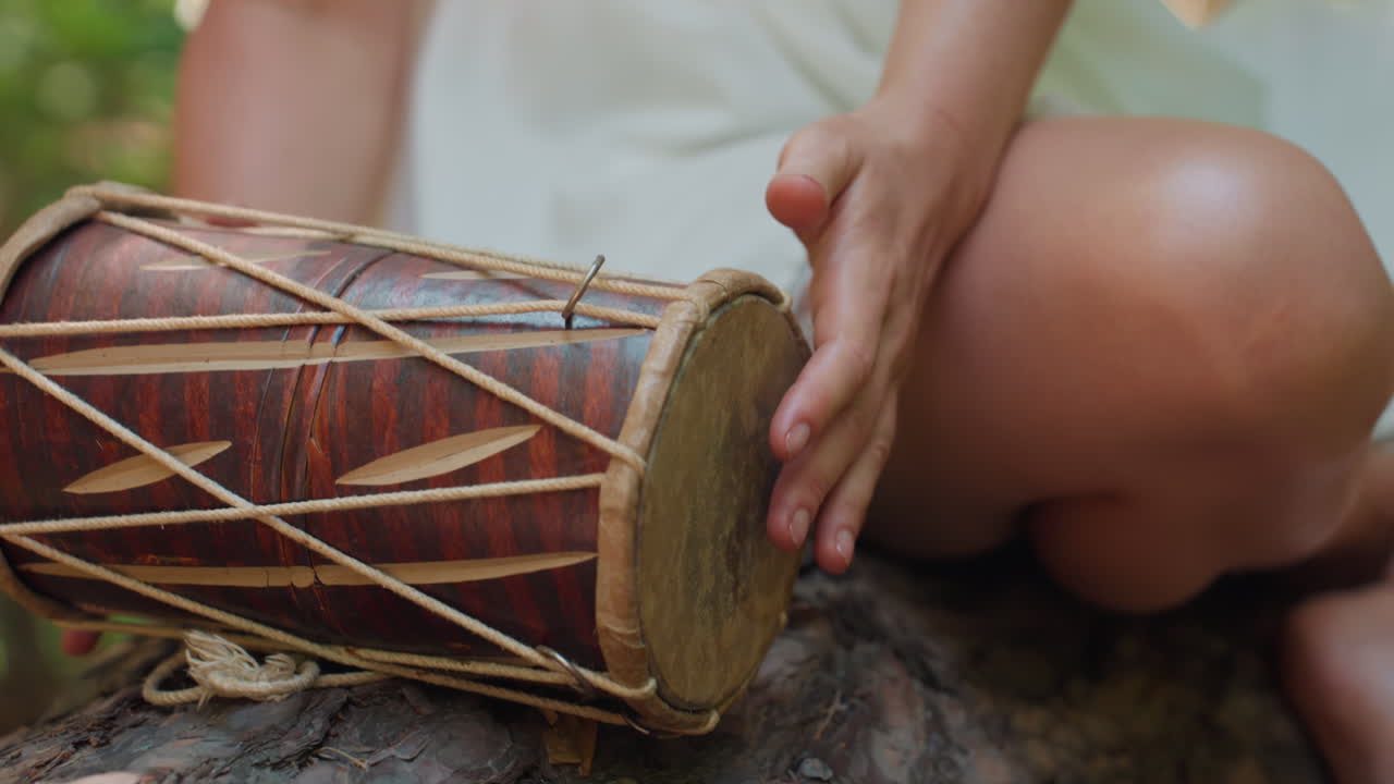 Close up of magical creature gently returning traditional drum onto forest log, sunlight glimmering on wooden surface and leather weave, evoking ancient rhythm
