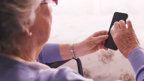 mujer mayor usando teléfono móvil