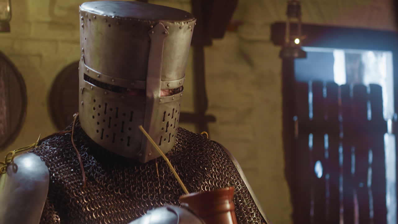 el caballero toma una bebida con paja en la taberna. el guerrero aventurero ordena bebidas alcohólicas en la casa de huéspedes al viajar. el soldado medieval descansa en el pub