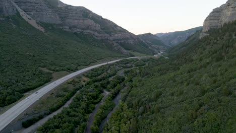 Vista-Aérea-De-Los-Automóviles-Que-Conducen-En-La-Carretera-Del-Cañón-Provo-A-Lo-Largo-Del-Río-Provo-A-Través-De-Las-Cadenas-Montañosas-En-Utah