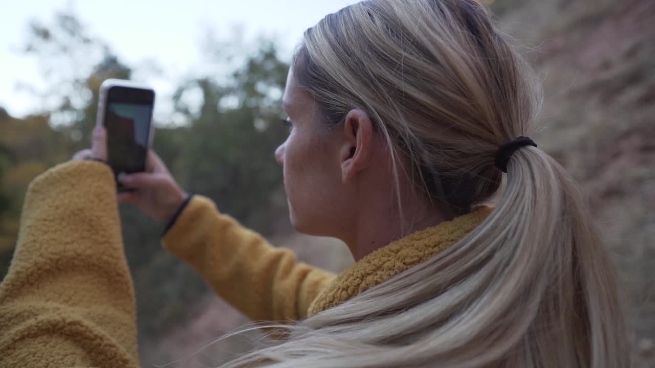 mujer tomando fotografías de acantilados en el parque nacional zion.