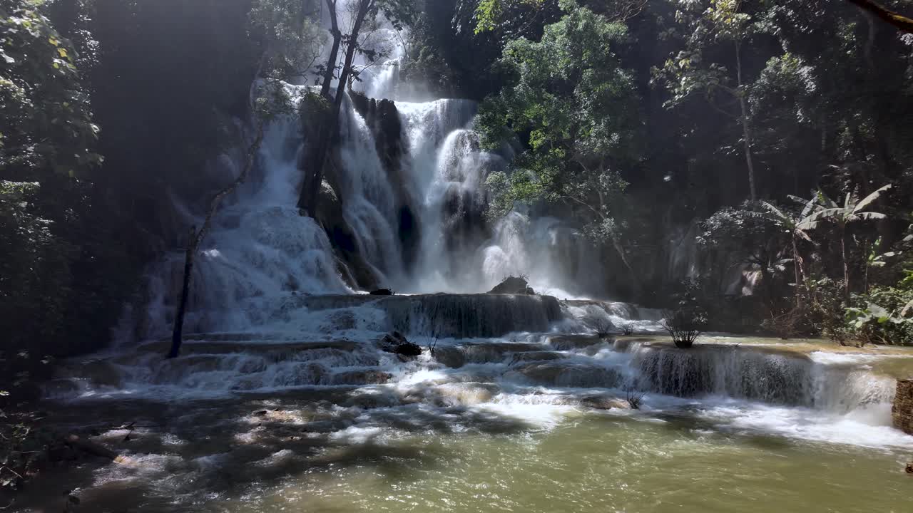 Thác Kuang Si chảy qua các thành tạo đá vôi trong khu rừng nhiệt đới xanh tươi của Lào. Chậm, quay quét