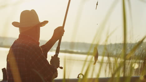 close-up view of caucasian senior man fishing on a boat in the lake on a cloudy morning