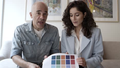 confident young woman with mature colleague showing color palette