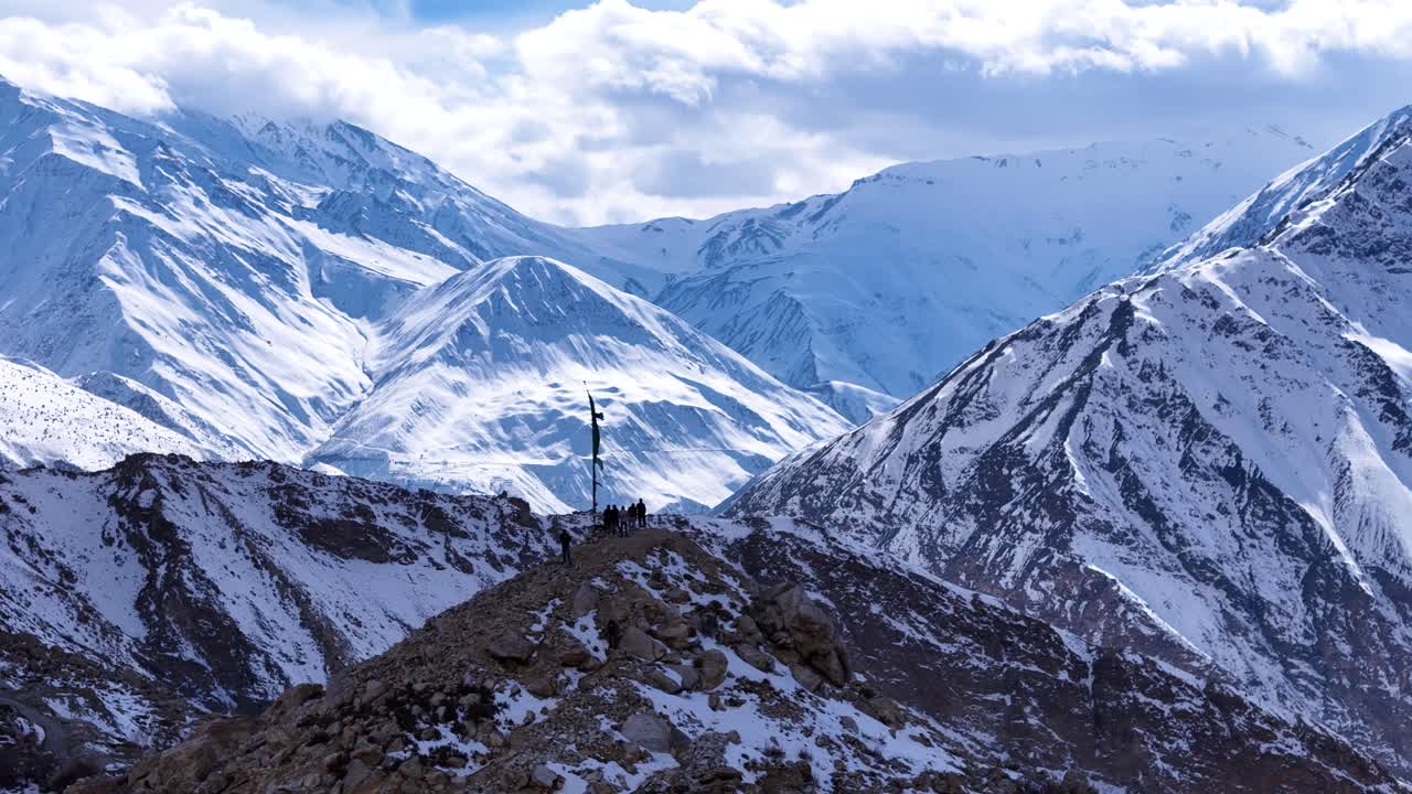 Snowy Mountain Summit with Flag and Hikers