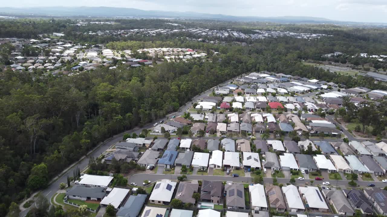 Aerial view of an Australian suburb with dense private homes and a green strip near by