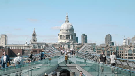 walking across the millennium bridge towards st. paul's cathedral in london