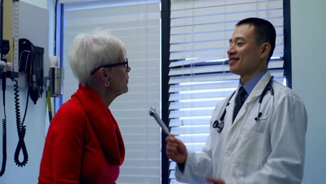 Young-Asian-male-doctor-examining-a-senior-patient-with-tuning-fork-in-the-clinic-4k