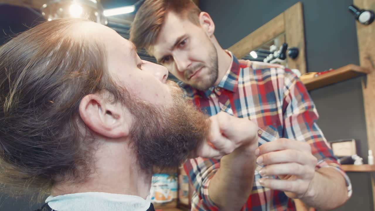 Man Getting a Haircut and Beard Trim at the Barber Shop
