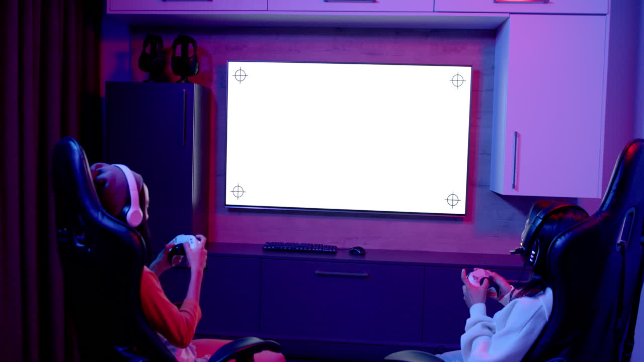 Playing video games, two teenage girls using controllers and wearing headsets, copy space