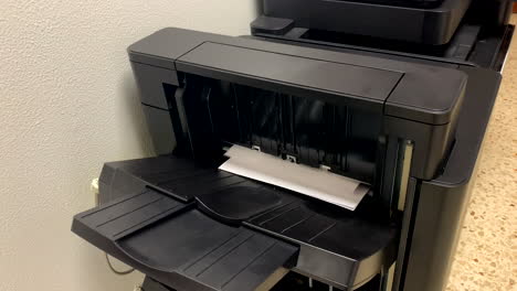 man-prints-on-the-printer-in-the-office