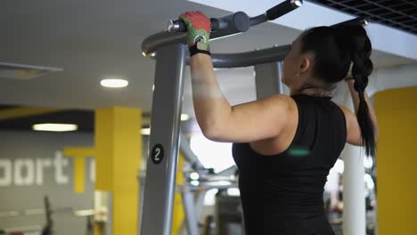 woman performing pull-ups in gym