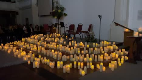 candlelight concert setup inside st jude’s church in southsea, with warm, glowing candles illuminating the space.