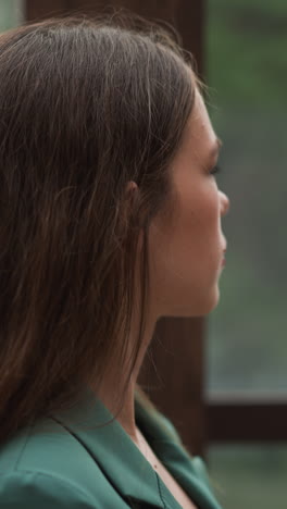 businesswoman paces beside large windows. palpable sense of disappointment fills room as quarterly earnings fall far below projections. aura of command