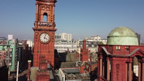 Drohnenflug-Aus-Der-Luft-über-Das-Zufluchtsgebäude-An-Der-Oxford-Road-Im-Stadtzentrum-Von-Manchester,-Das-Die-Gotische-Architektur-Und-Die-Umliegenden-Dächer-Zeigt