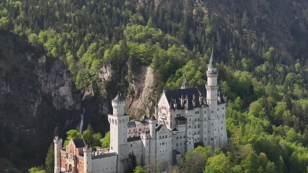 un muñeco aéreo fuera de un hermoso castillo blanco escondido en el bosque verde de la cima de la montaña