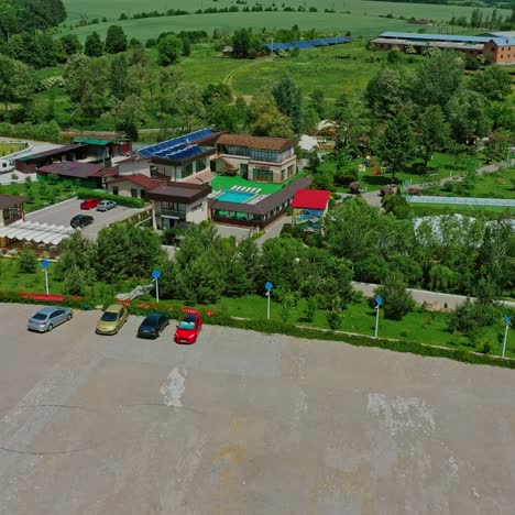 recreation complex among green nature. place for car parking near the resting zone. innovative solar panels on roofs and field in summer. aerial view.