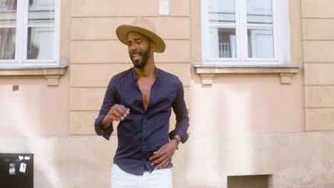 uomo afro-caraibico sorridente con cappello panama che balla salsa da solo in strada 2