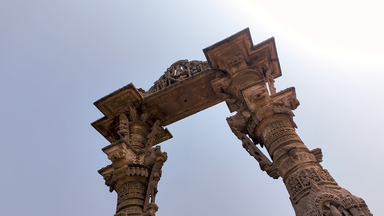Vadnagar, Gujarat, India, sudut rendah gerbang Kirti Toran yang menampilkan arsitektur batu kuno, pilar berukir, monumen bersejarah, warisan budaya India, keahlian era kuil, dan landmark pariwisata