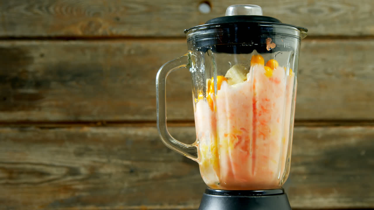 jugo de fruta siendo molido en el exprimidor 4k