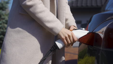 Woman-charging-an-electric-car