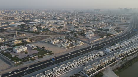 Drone-view-of-Ajman-City,-urban-traffic-and-traditional-houses-in-the-United-Arab-Emirates,-4k-Footage