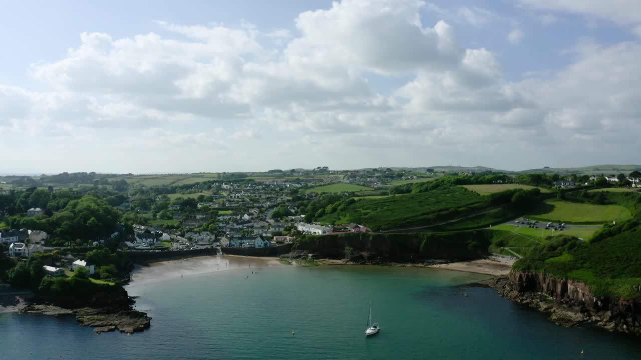Wide drone shot of Dunmore East, Ireland on a sunny day.