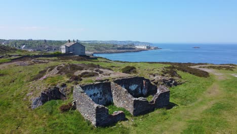 Abandoned-Amlwch-coastal-countryside-mountain-house-aerial-low-orbit-left-view-overlooking-Anglesey-harbour