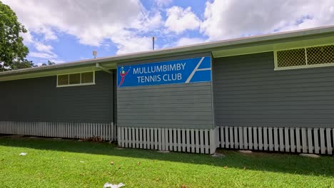 A serene view of Mullumbimby Tennis Club with lush greenery and clear skies, captured in bright daylight