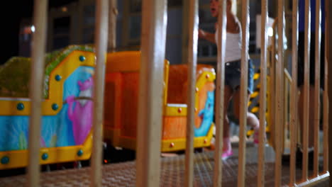 child on a colorful amusement park ride behind bars