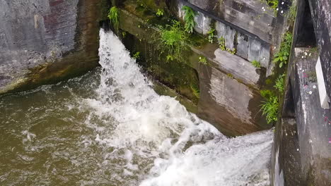 Super-Slow-Motion-Close-Up-of-Wooden-Canal-Lock-Gates-Closed-with-Water-Escaping-Through-Small-Gaps