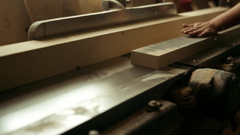 unknown carpenter cutting wood in workshop. man preparing plank in studio