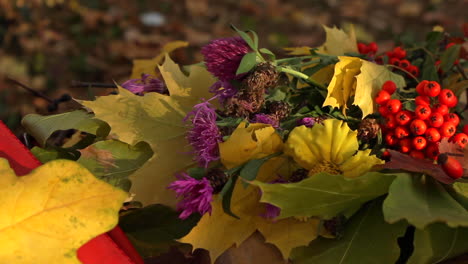 Autumnal-flowers-with-red-berries-resting-on-bench