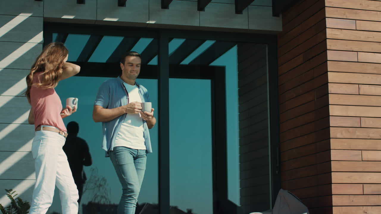pareja hablando afuera en cámara lenta. hombre y mujer bebiendo café en la terraza.