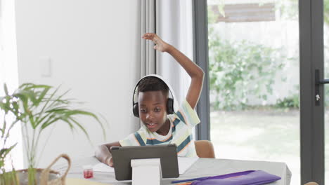 african american boy studies at home using a tablet
