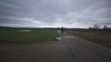 Modern-Black-Swordsman-Warrior-Awaiting-Battle-Opponent-in-Open-Field-Under-Grey-Sky,-Europe,-4K-|-Muscular,-Intimidating,-Shadow,-Figure,-Blurry,-Dark-Clothes,-Powerful,-Distant-Stand,-Walk-Towards