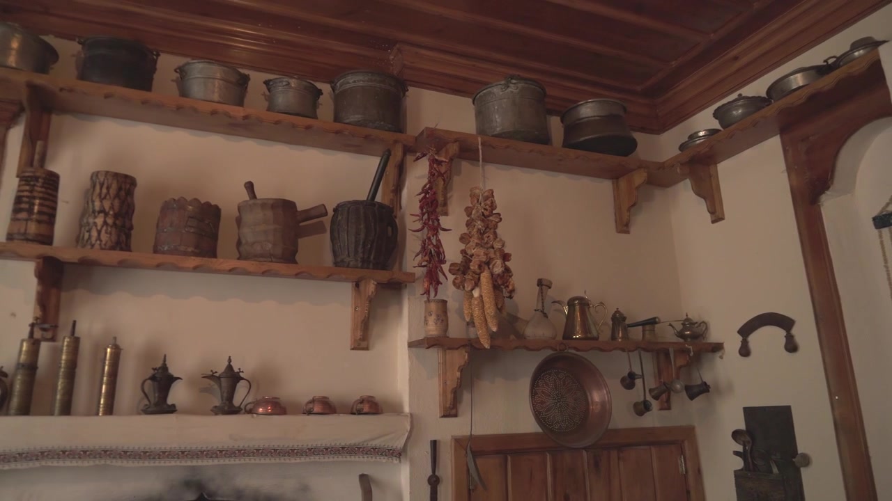 Interno di Cucina Rustica Tradizionale con Pentolame Antico in Rame e Utensili in Legno