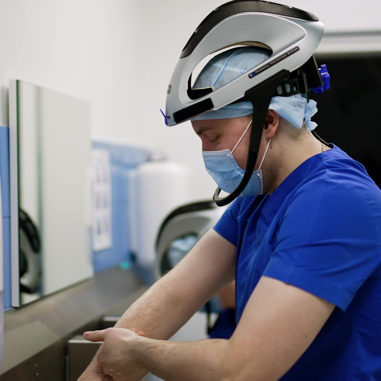 Male Caucasian doctors wearing special helmets wash hands carefully. Surgery specialists prepare for operation